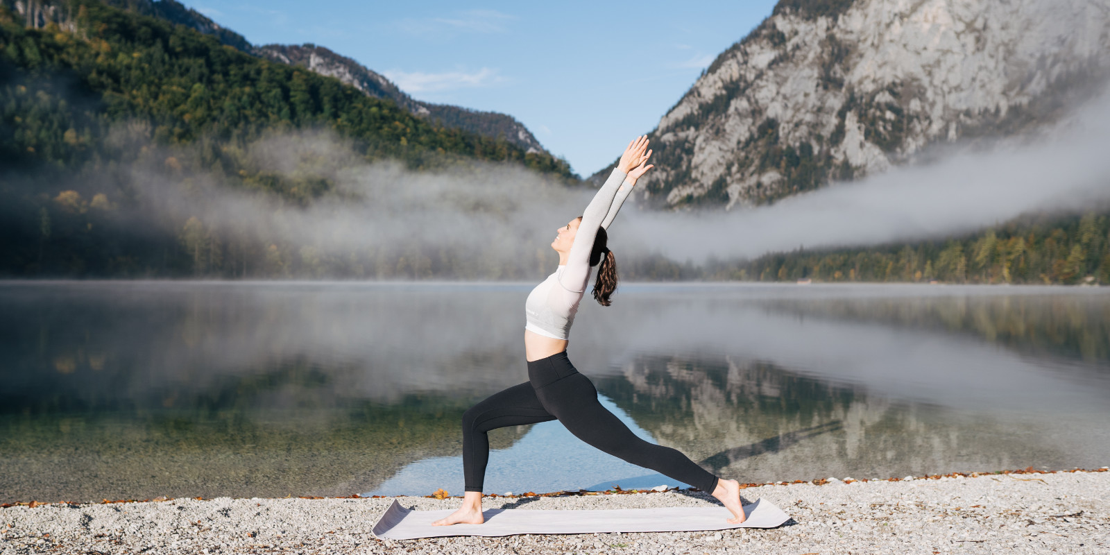 Klara Fuchs macht Yoga an einem idyllischen See mit Bergkulisse