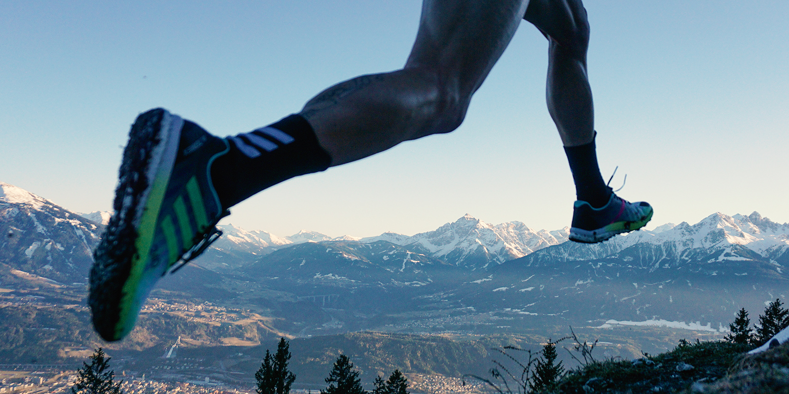 Die Beine von Moritz auf der Heide in einer Bergkulisse beim Laufen 
