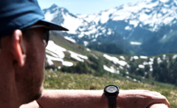 Mann blickt bei einer Pause auf seiner Wanderung auf die Berge