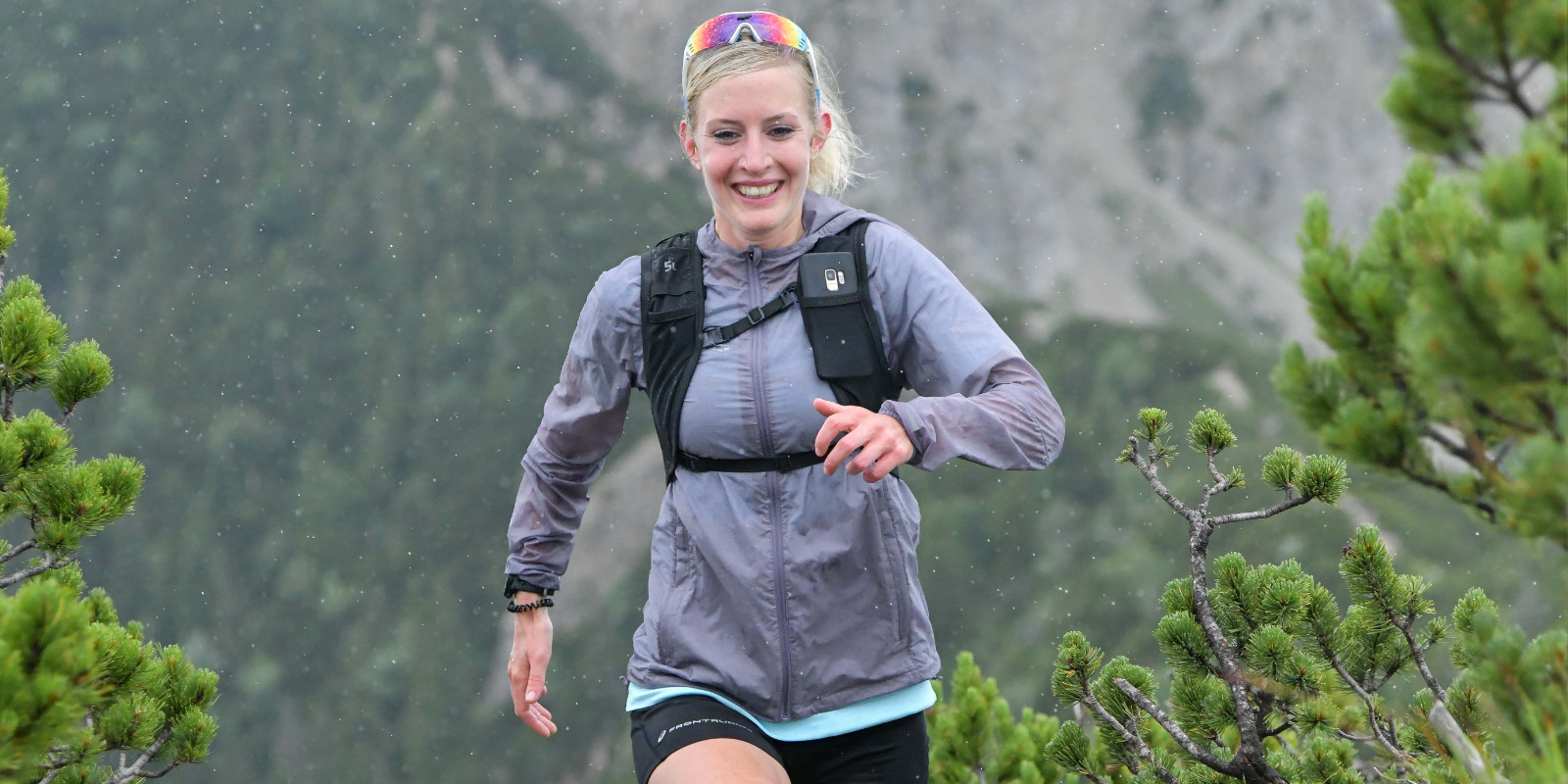 Juliane Ilgert glücklich und lächelnd beim Traillaufen in den Bergen
