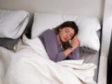 Frau mit Garmin Uhr schläft ihrem Bett