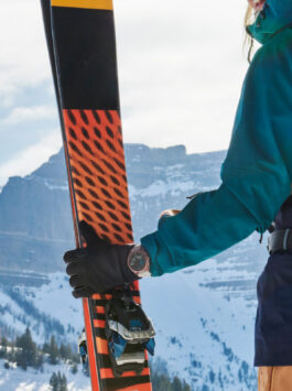 Frau steht mit ihrer fenix 7 auf einem Berg und will Skifahren