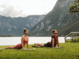 Frau und Mann machen Yoga an einem See