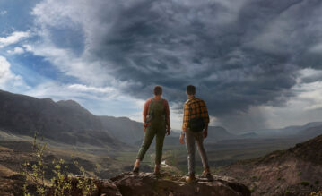 Mann und Frau stehen auf einem Berg und genießen die Aussicht