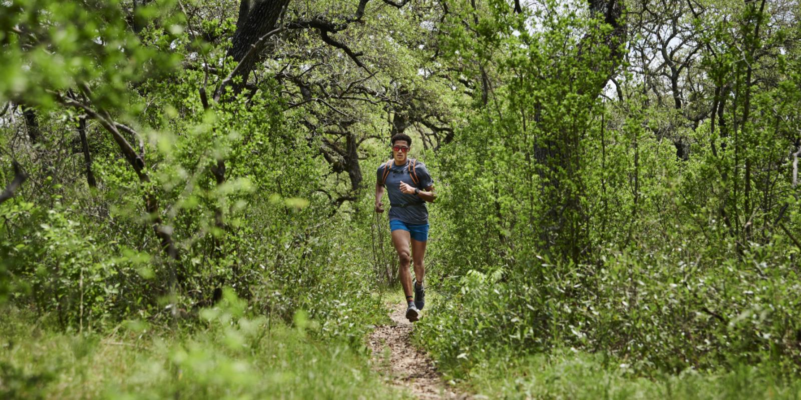 Trailrunner läuft mit seiner Garmin epix durch den Wald