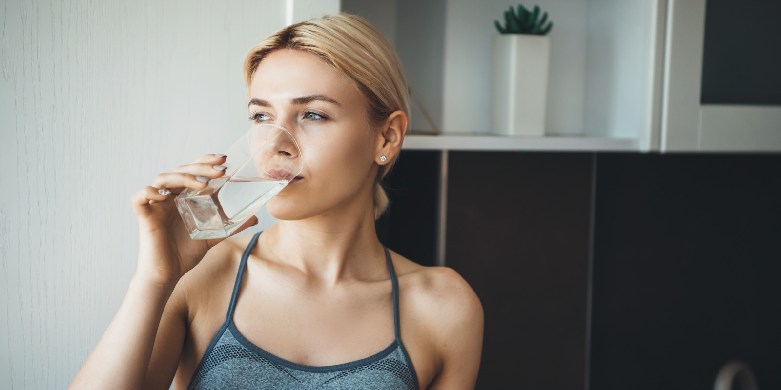 Frau trinkt Wasser während ihrer Darmsanierung