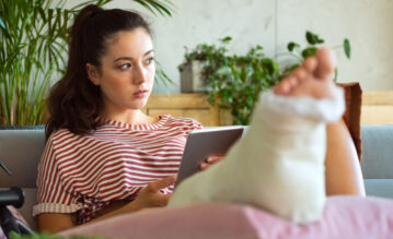 Frau mit gebrochenem Fuß zu Hause