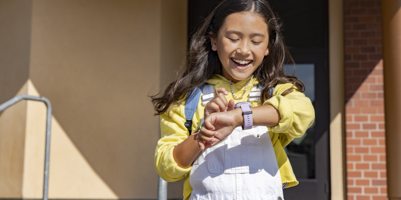 Kind mit Garmin Bounce am Handgelenk läuft fröhlich aus der Schule