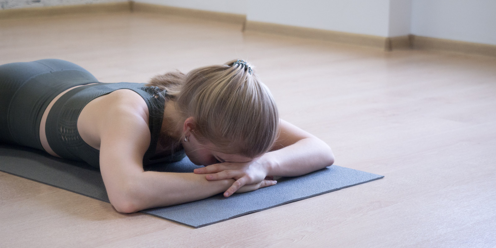 Frau liegt auf dem Bauch und atmet, um ihr Zwerchfell zu trainieren