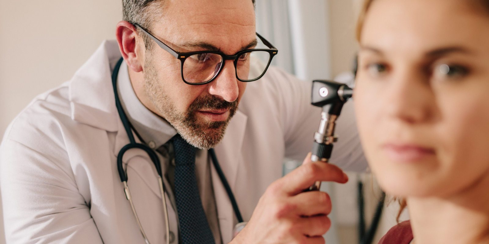 HNO-Arzt untersucht das Ohr einer Patientin