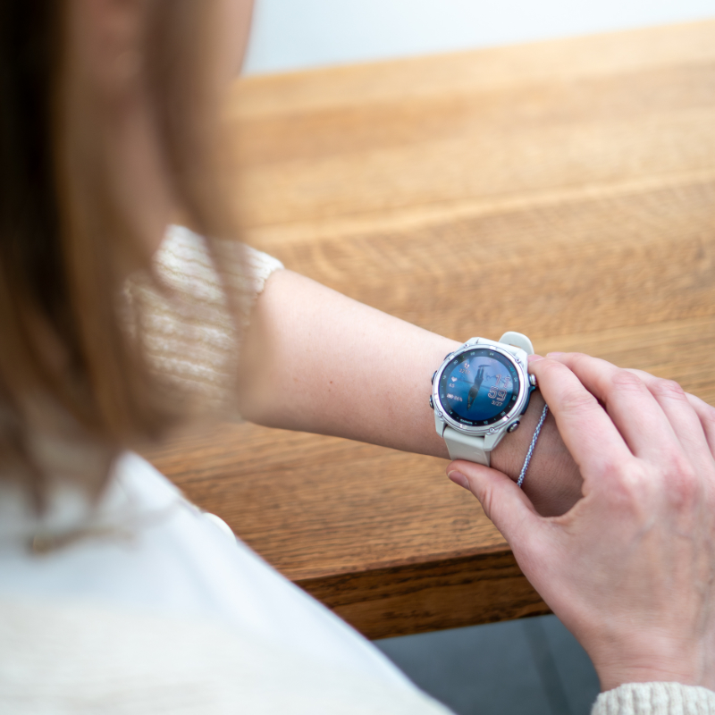 Jennifer Wendland schaut auf ihre Garmin-Uhr mit Tauchmotiv als Hintergrundbild