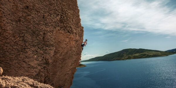 Mann mit fenix 8 am Handgelenk beim Klettern an einem Felsen