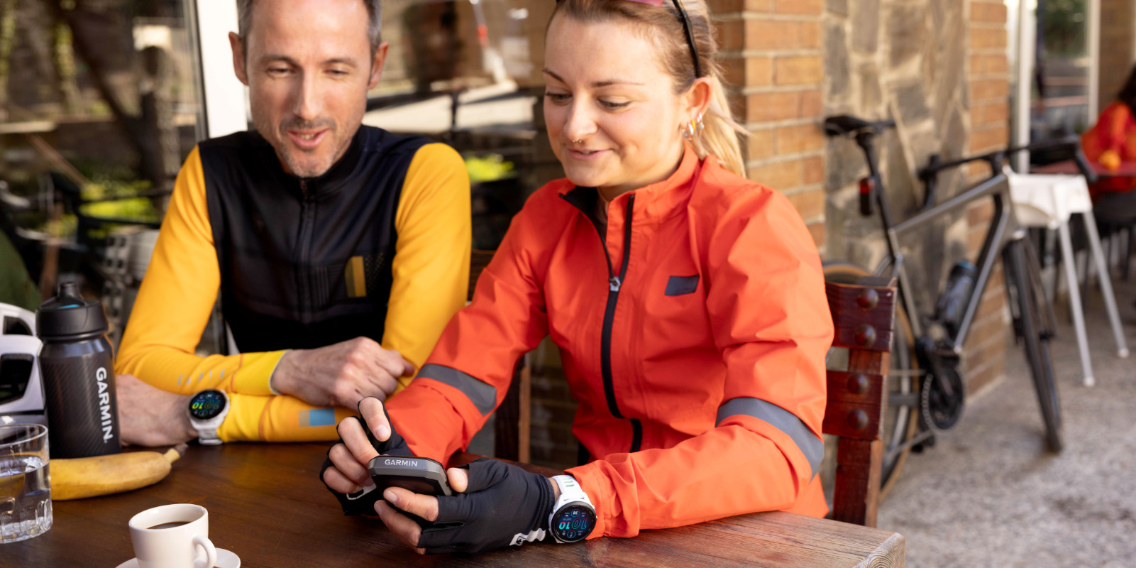 Radfahrerin und Radfahrer tauschen sich in einem Cafe über ihre GroupRides Ergebnisse auf dem Edge aus.