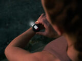 Eine Frau in Sportbekleidung trägt den neuen Forerunner 970 von Garmin am Handgelenk und nutzt die Funktion Taschenlampe in der Dunkelheit.