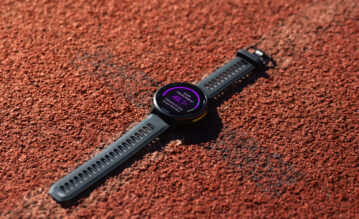Forerunner 970 von Garmin auf einer Tartanbahn liegend mit der Anzeige der Running Tolerance auf dem Display
