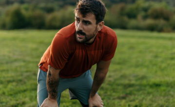Mann ist außer Puste beim Lauftraining und atmet hecktisch während der Pause