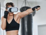 Eine Frau in sportlicher Kleidung trägt eine VR-Brille und schlägt eine Gerade.