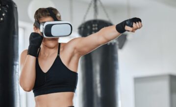 Eine Frau in sportlicher Kleidung trägt eine VR-Brille und schlägt eine Gerade.