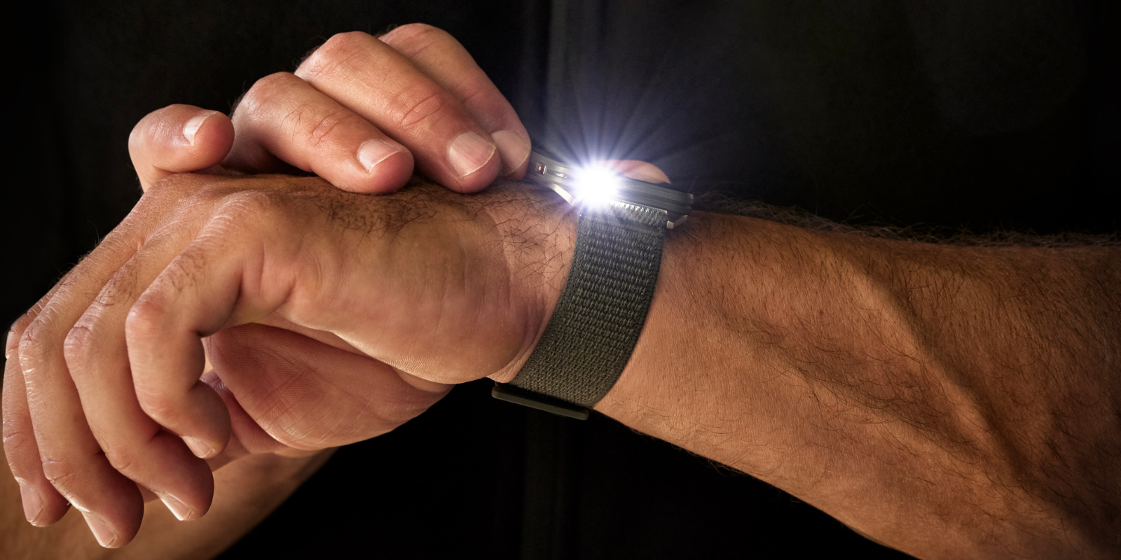 Mann benutzt die Taschenlampe an seiner Garmin Venu X1