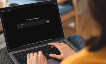 Junge Frau sitzt vor dem LapTop und hat CHatGPT geöffnet