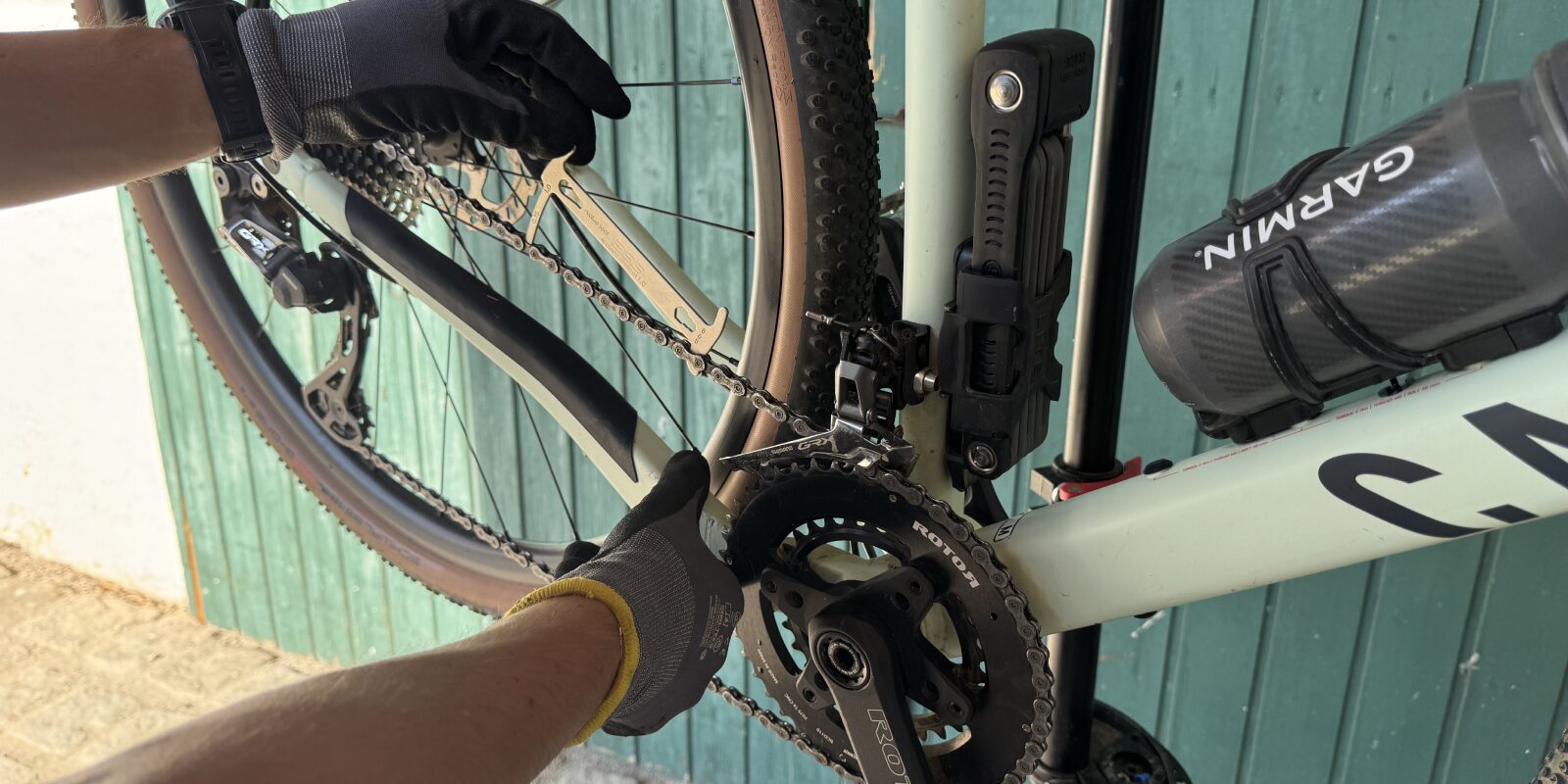 Eine Person überprüft den Verschleiß ihrer Fahrradkette mit passendem Werkzeug.