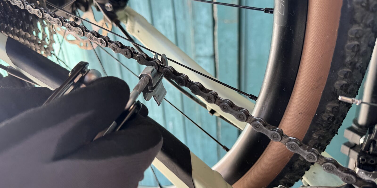 Eine Person öffnet seine Fahrradkette mit einem Nietdrücker.