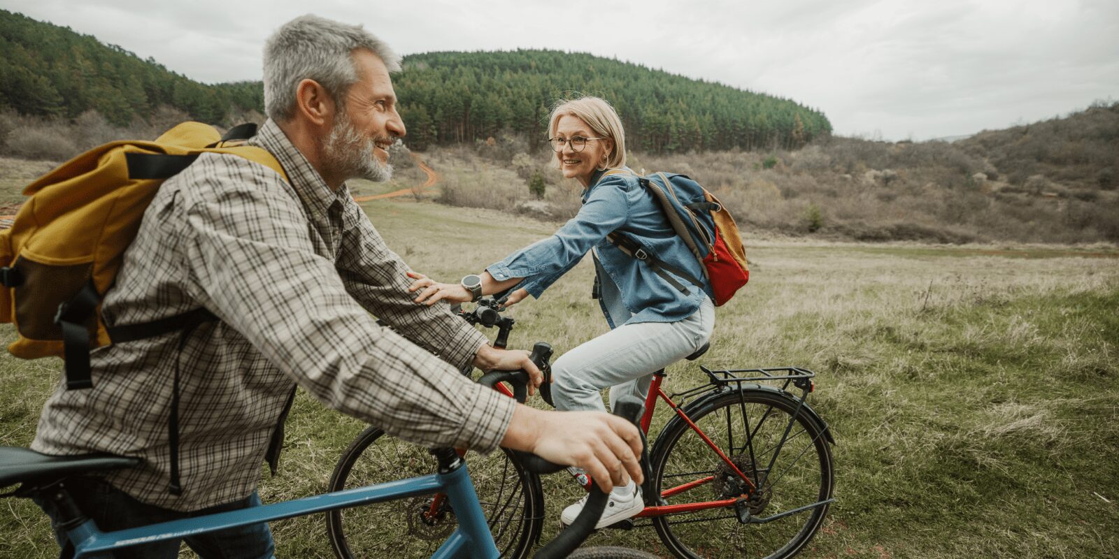 Ein Mann und eine Frau sind mit dem Rad in der Natur unterwegs.